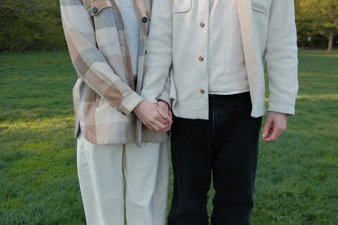 Detail of the couple holding hands, framed at the waist