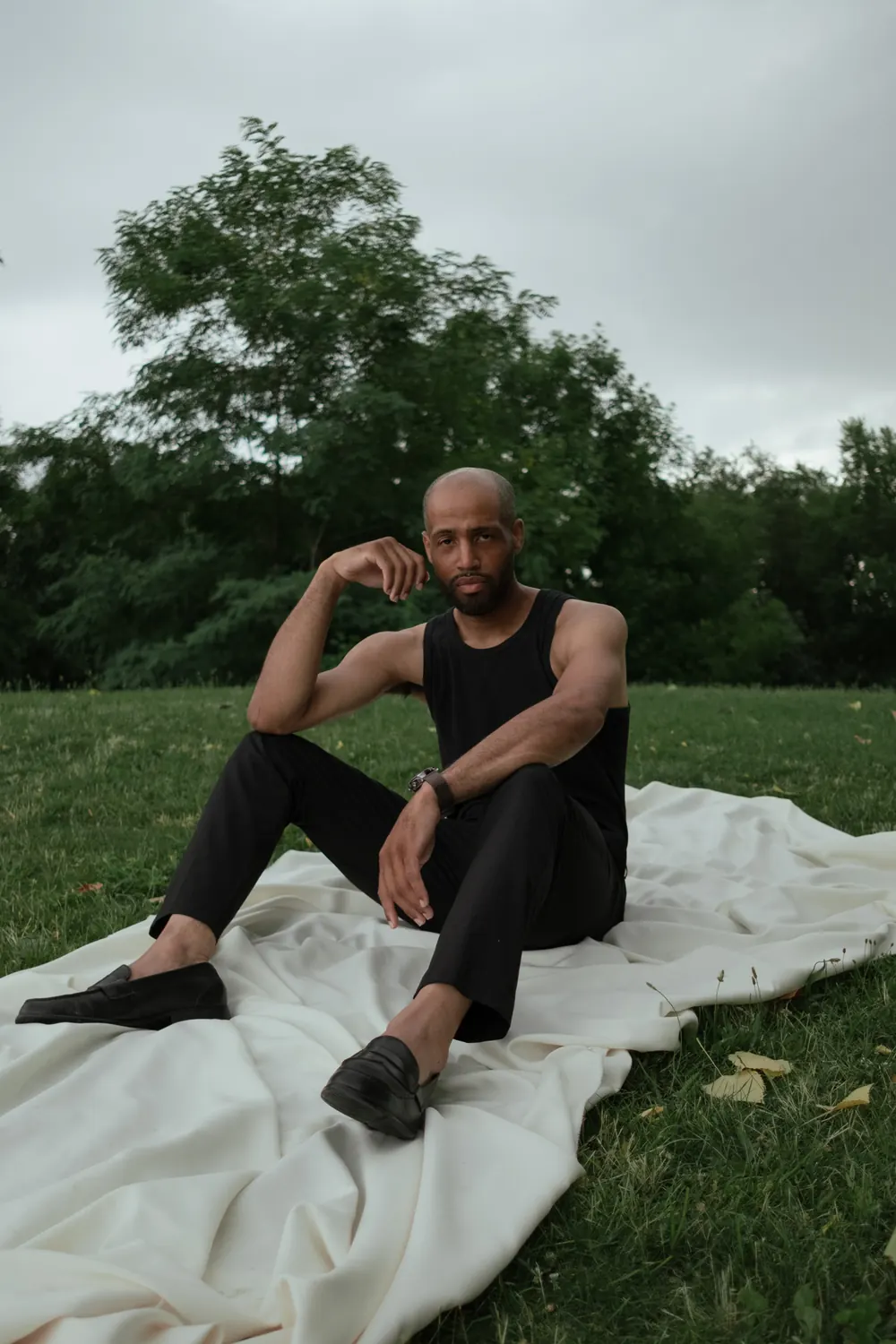 Man sitting on a white sheet in the grass